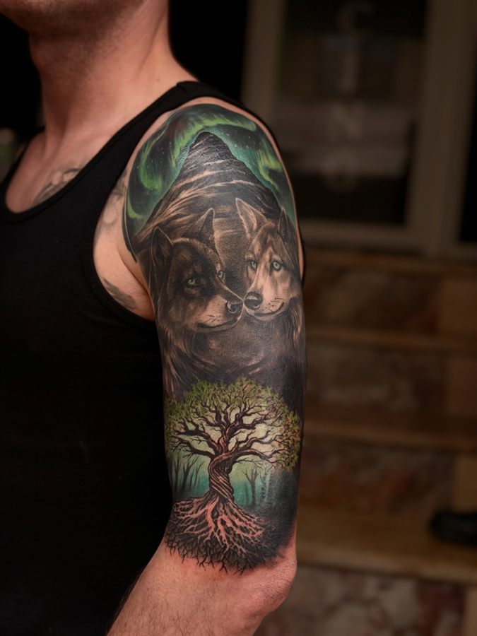 Tatuaj color cu lup și copac pe umăr