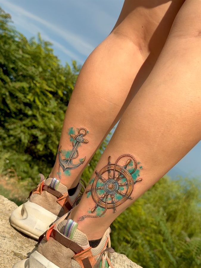 Tatuaje color cu ancoră și timonă pe gleznă